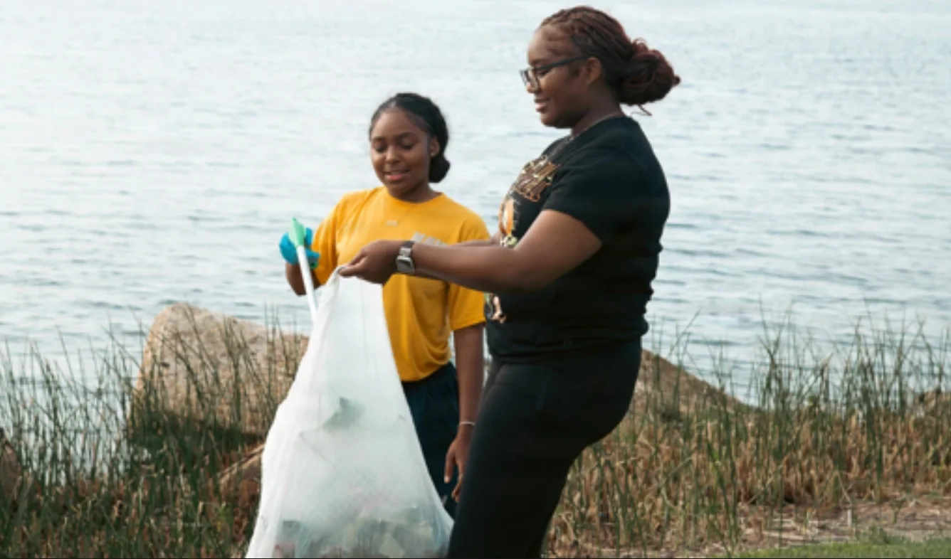 Young volunteers serving together near the water